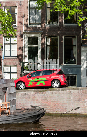 Ein Green Wheels Auto für Car-sharing, dating, kurzfristige Vermietung an einer Gracht in Amsterdam. Peugeot 207. Stockfoto