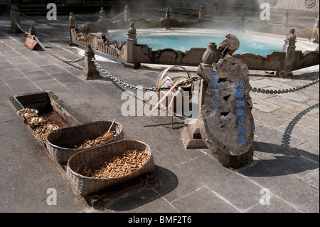 Sprudel gekochten Eiern und Erdnüsse verkauft neben großen Topf mit kochendem, Rehai geothermischen Feld, Yunnan, China Stockfoto