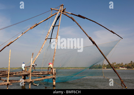 Indien, Kerala, Kochi, Fort Cochin, Männer Fang Chinese Fishing Net gesucht Stockfoto