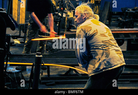 Bill Pinchers Fütterung Bandstahl durch die Mühle am John Legg in Ettingshall, Wolverhampton Stockfoto