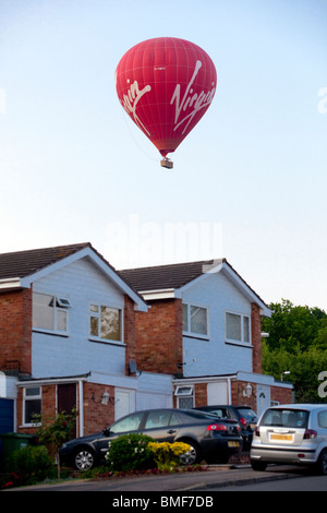 Einem roten Heißluftballon Tiefflug über Wohnhäuser in WOrcestershire, England, UK Stockfoto