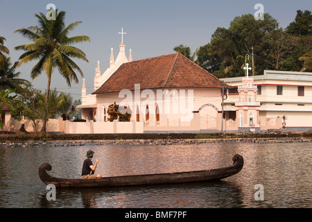 Indien, Kerala, Alappuzha, Chennamkary, westliche Mensch paddelt hölzernes Kanu entlang Pamba Fluß an syrisch-orthodoxen Kirche St. Thomas Stockfoto