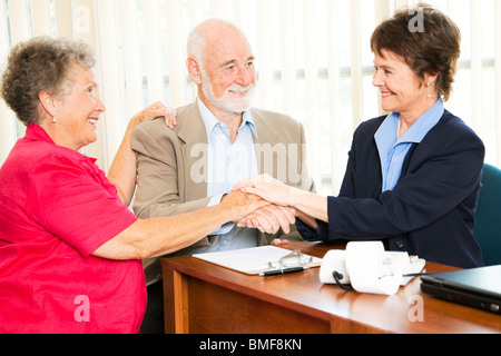 Älteres paar schüttelt Hände mit ihren Finanzberater oder Makler. Stockfoto