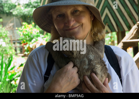 Frau mit einem Baby Brown-throated Dreifingerfaultier in ihren Armen, Amazonas, Brasilien
