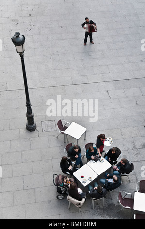 Ein Straßenmusikant unterhält Café-Gäste in der Plaza de Santa Cruz im Zentrum von Madrid. Stockfoto