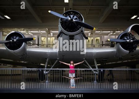 Zwei junge Mädchen spielen unter einer Junkers Ju 52 / 3m dreimotorigen Flugzeug fliegen Stockfoto