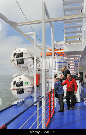 Touristen unter aufblasbare Rettungsinseln in hartschaligen Kanister und Rettungsboot an Bord der Fähre, Europa Stockfoto