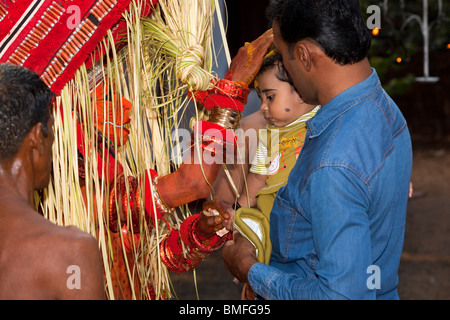 Indien, Kerala, Cannanore (Kannur), Theyyam Schlange Gottheit Naga Kanni geben junge Kind segnet es zuerst Stockfoto