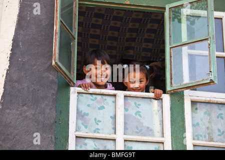 Tibetische Mädchen in einem Fenster in Gyantse, Tibet Stockfoto