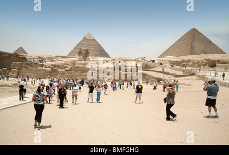 Ägypten reisen; Touristen auf dem Plateau von Gizeh mit der Sphinx suchen und die drei wichtigsten Pyramiden, Giza, Kairo, Ägypten Stockfoto