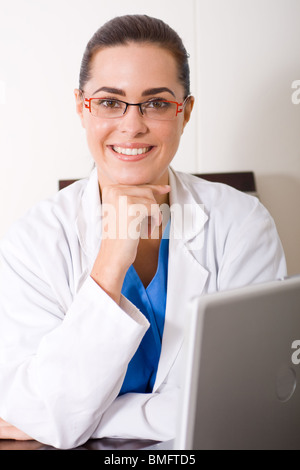 zufrieden Ärztin von ihrem Laptop sitzen Stockfoto