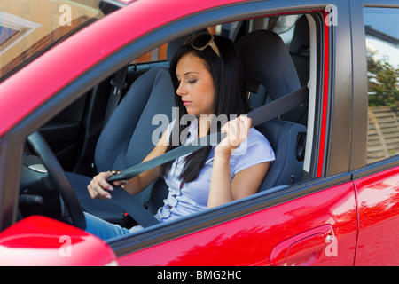 Junge Frau befestigt den Sicherheitsgurt im Auto Stockfoto