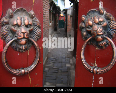Lion geformte Griffe auf dem Tor ein Hutong Hofhaus, Peking, China Stockfoto