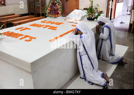 Indien Kalkutta Kalkutta, Nonne beten am Grab von Mutter Teresa an der Mutter Teresa Haus, mit Blumen Liebe geschrieben, bis es weh tut Stockfoto