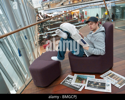 Ein Schüler liest eine Zeitung auf dem Flughafen Stockholm-Arlanda. Stockfoto