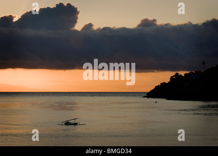 Wenn die Sonne in Amed, Bali, Fischer in ihren kleinen Booten genannt Jukung zurück ans Ufer aufgeht, um ihren Fang des Tages zu entladen. Stockfoto