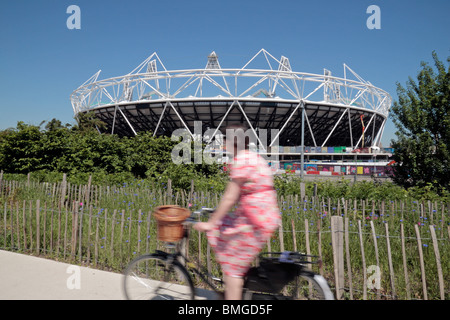 Ein Radfahrer auf der Greenway übergibt die teilweise gebauten London 2012 Olympischen Leichtathletik-Stadion in Stratford, London. (Juni 2010) Stockfoto