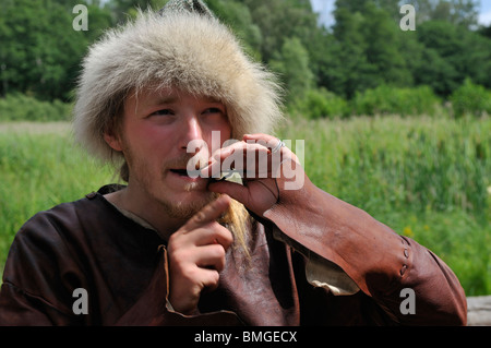 Mann in Viking Kostüm spielt Jude s Harfe in der Viking Stadt Birka auf Bjoerkoe Insel, UNESCO-Welterbe, Schweden Stockfoto