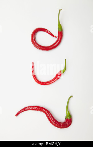 Drei rote Jalapeno Peppers eingerollt in einzigartigen Formen Stockfoto