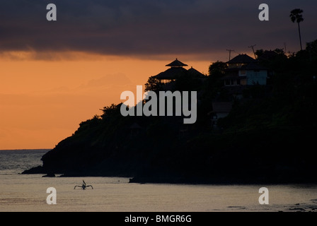 Wenn die Sonne in Amed, Bali, Fischer in ihren kleinen Booten genannt Jukung zurück ans Ufer aufgeht, um ihren Fang des Tages zu entladen. Stockfoto