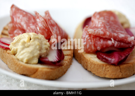 Milano Salami auf Bruschetta mit Houmous Stockfoto