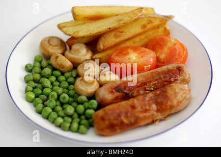 Frisch gekochte Mahlzeit von Wurst aus Schweinefleisch mit Chips Erbsen, Champignons und Tomaten auf einem Tisch mit Keine Personen Stockfoto