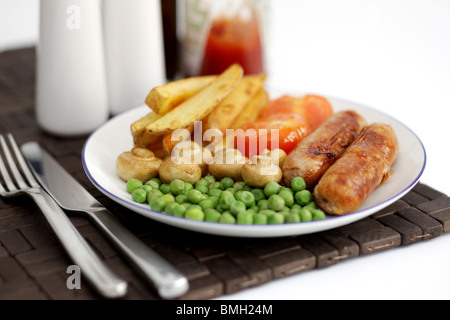 Frisch gekochte Mahlzeit von Wurst aus Schweinefleisch mit Chips Erbsen, Champignons und Tomaten auf einem Tisch mit Keine Personen Stockfoto