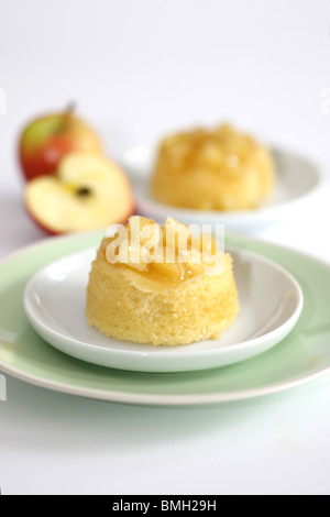 Traditionelle authentische britische's Dessert Eve Pudding mit Apfelkompott vor einem weißen Hintergrund und kein Volk Stockfoto