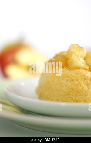 Traditionelle authentische britische's Dessert Eve Pudding mit Apfelkompott vor einem weißen Hintergrund und kein Volk Stockfoto