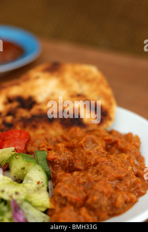 Frisch zubereitete im indischen Stil würziges Rindfleisch Madras Curry mit Naan Brot und frischen Salat mit Keine Personen Stockfoto