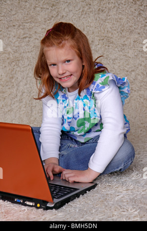 Porträt eines jungen Mädchens, das sitzen auf dem Boden mit ihrem laptop Stockfoto