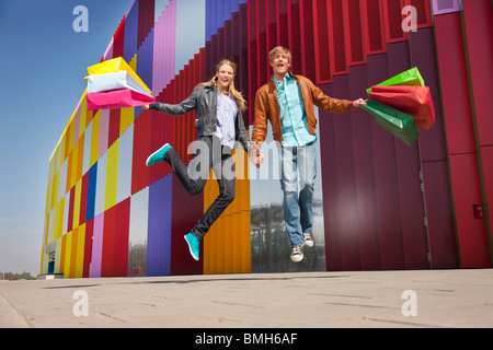 Springen mit farbigen Tragetaschen Stockfoto