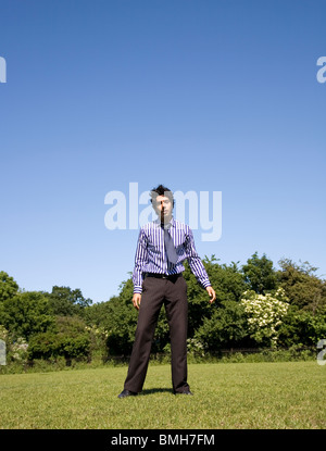 Mann in Businesshemd, Krawatte und Hose im Park stehen Stockfoto