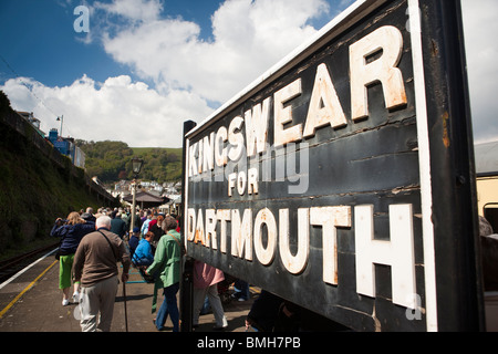 Großbritannien, England, Devon, Kingswear Bahnsteig, Dampf Zugpassagiere zu Fuß vorbei an Dartmouth-Schild Stockfoto