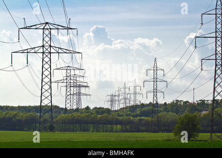 Hohe Spannungen Drähte in grüne Sommerlandschaft und leicht bewölktem Himmel Stockfoto