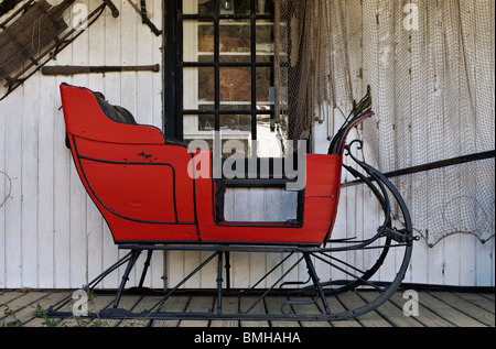 Roter Schlitten auf der Veranda an der Diebe Markt Antiquitätenladen in Mount Pleasant, South Carolina Stockfoto