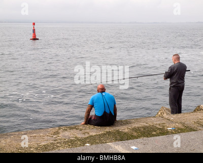 Zwei Männer Makrelen angeln am Ende des South Gare Wellenbrecher am Teesport Stockfoto