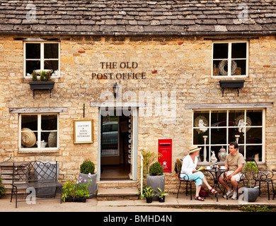 Ein paar beim Tee außerhalb der alten Post in Gloucestershire Cotswold Dorf Guiting Power, England, Großbritannien Stockfoto