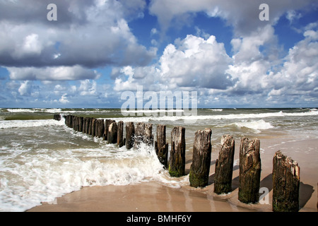 Windiger Tag am Meer. Wellenbrecher und Wellen gegen bewölktem Himmel. Ostsee in Polen. Stockfoto