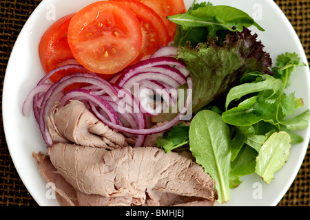 Frisch zubereitete Kaltes Roastbeef Salat mit Tomaten, roten Zwiebeln und grünen Blättern, die keine Menschen Stockfoto