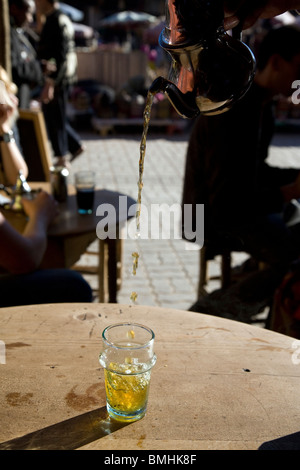 Eine Kellnerin gießt grüner Tee mit Minze im Cafe des Espices, in der Spice Souk von Marrakesch, Marokko. Stockfoto