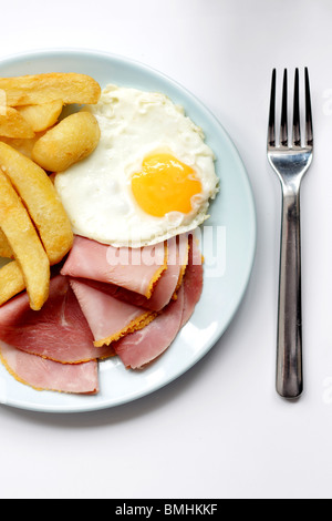 Ein frisch zubereitetes Spiegelei Sunny Side Up mit Schinken und Chips serviert auf einem Teller mit Keine Personen Stockfoto