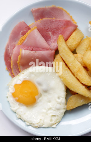 Ein frisch zubereitetes Spiegelei Sunny Side Up mit Schinken und Chips serviert auf einem Teller mit Keine Personen Stockfoto