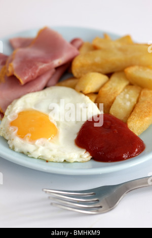 Ein frisch zubereitetes Spiegelei Sunny Side Up mit Schinken und Chips serviert auf einem Teller mit Keine Personen Stockfoto