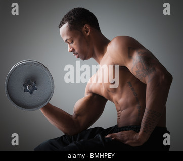 Muskulöser Mann eine Hantel heben Stockfoto