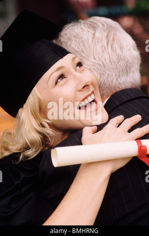Absolventen, die ihr Vater umarmen Stockfoto