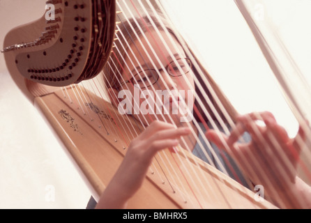 Junges Mädchen spielt die Harfe Stockfoto