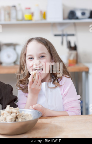 Junges Mädchen essen Cookie-Teig Stockfoto