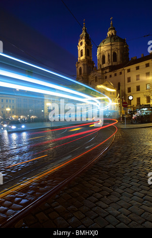 Lichtspuren aus einer Straßenbahn (Tramvaj) ziehen in eine Haltestelle vor St. Nikolaus auf der Kleinseite, Prag Stockfoto