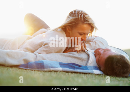 Paar, liegend auf der Picknickdecke Stockfoto
